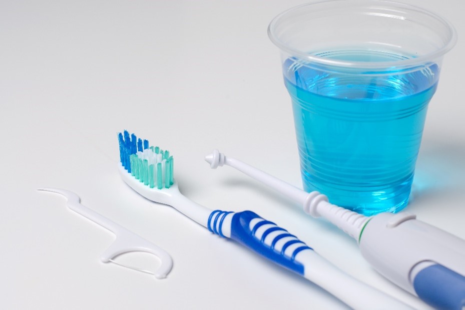 Hilfsmittel zur Mundhygiene: Zahnseide, Zahnbürste, Munddusche und Mundspülung.