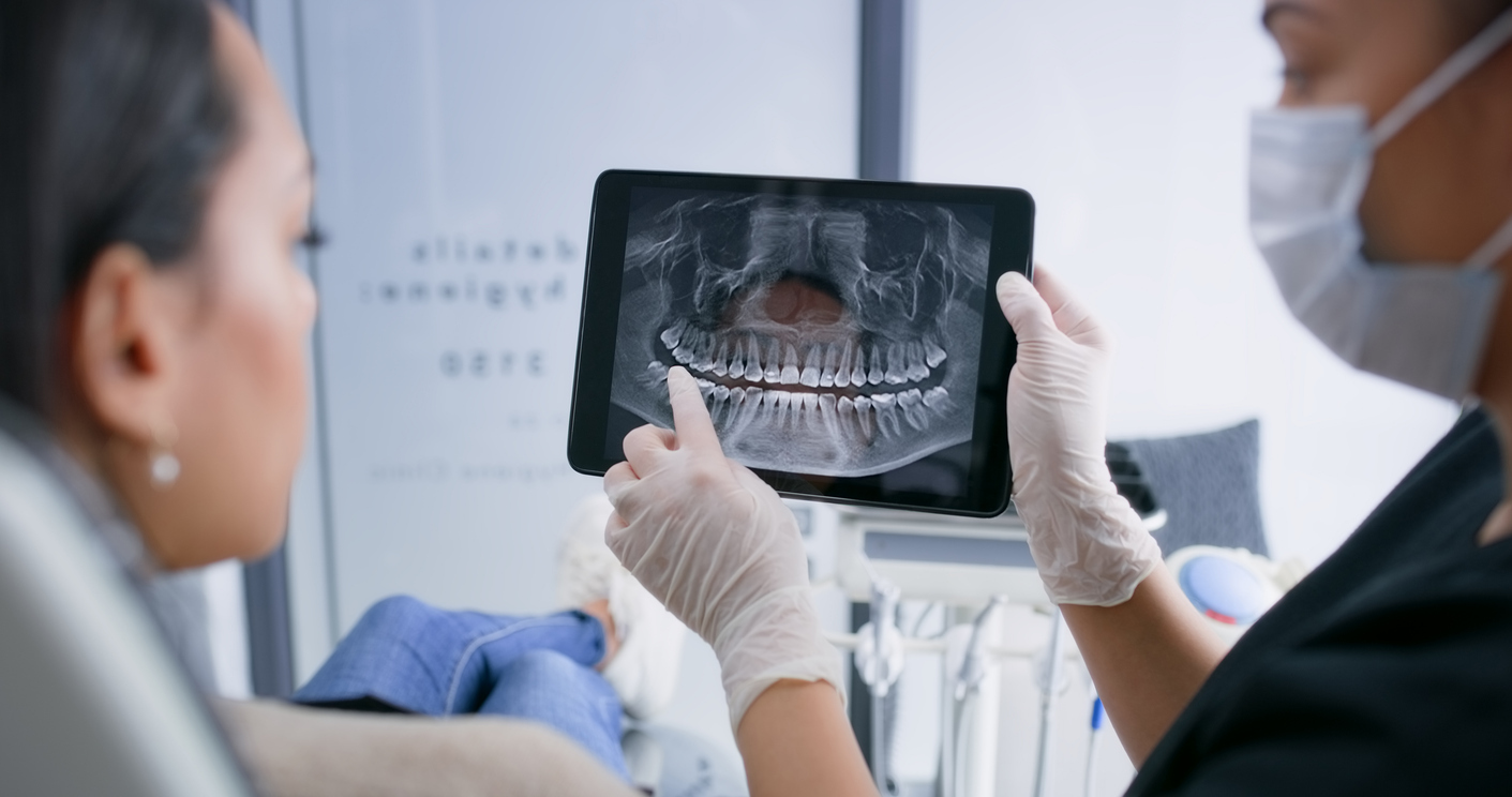 Röntgenbild Ein Zahnarzt bespricht mit seiner Patientin ihr Röntgenbild.