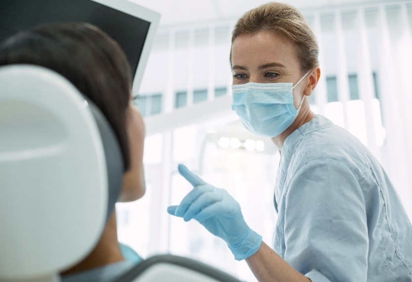 Eine Zahnärztin schaut sich die Zähne ihrer Patientin an.