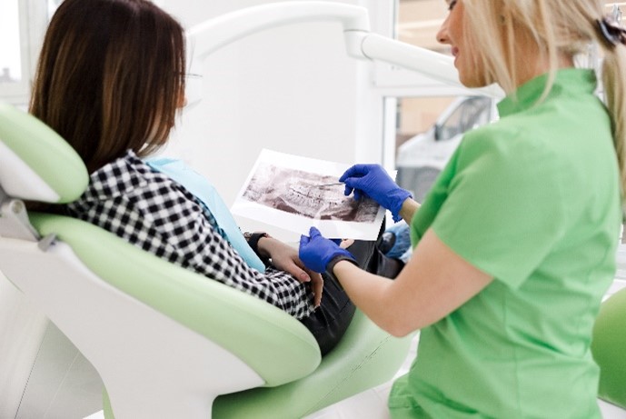 Eine Zahnärztin und ihre Patientin betrachten gemeinsam ein Zahnröntgenbild.